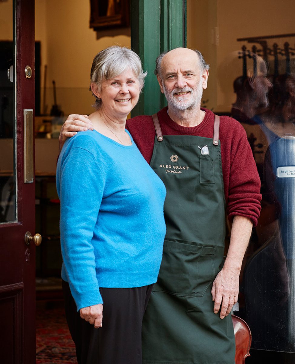 Marina-and-Alex-Grant at Grant Violins Marina and Alex Grant smiling in front of their Smith Street Violin Shop in 2022